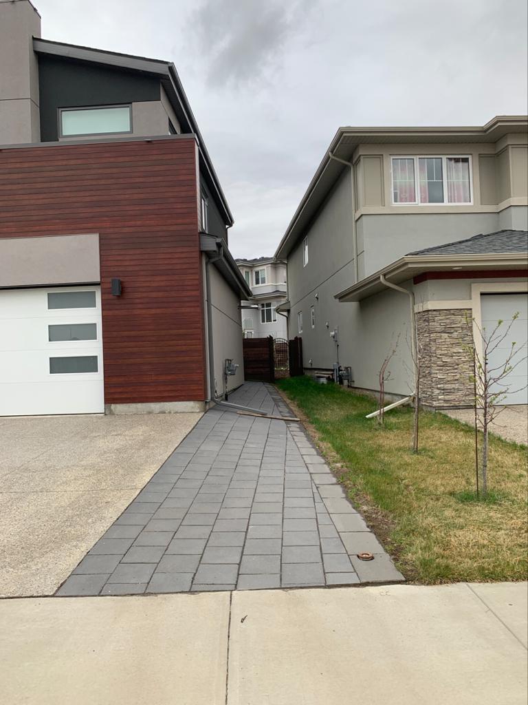 Paver walkway running along side of modern home